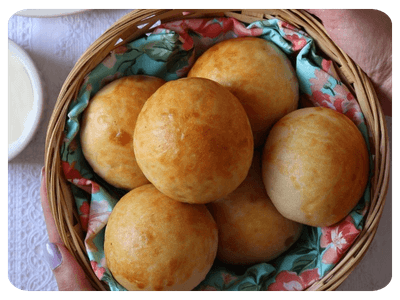 Pãezinhos redondos dourados em cesta de vime